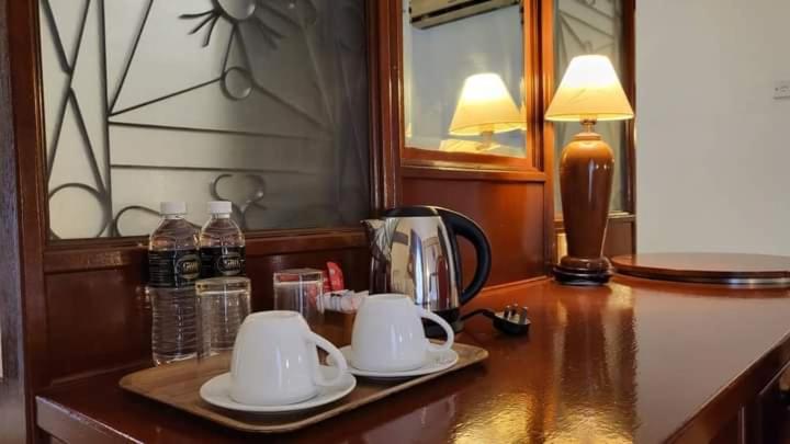 Hotel room amenities: complimentary mineral water, coffee, tea, kettle, and glassware setup.